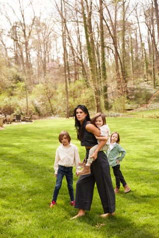 Image shows mom wearing matching black set and playing with children